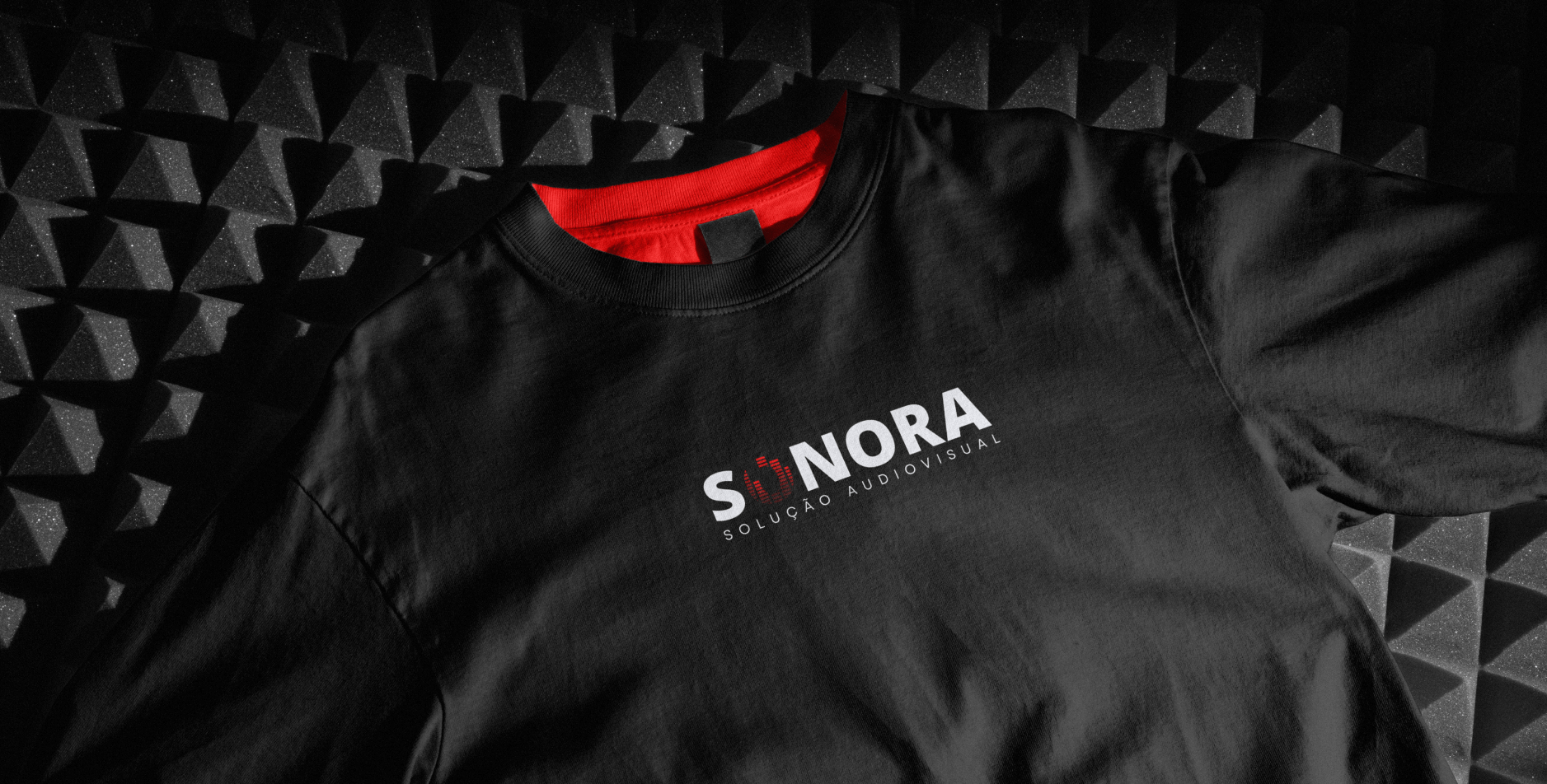 Camiseta preta com logotipo da Sonora Solução Audiovisual em ambiente de estúdio